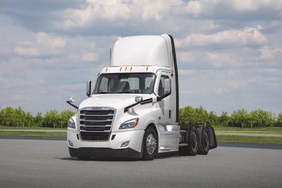 A white Class 8 truck on a tarmac.