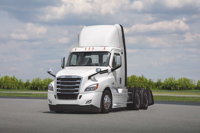 A white Class 8 truck on a tarmac.