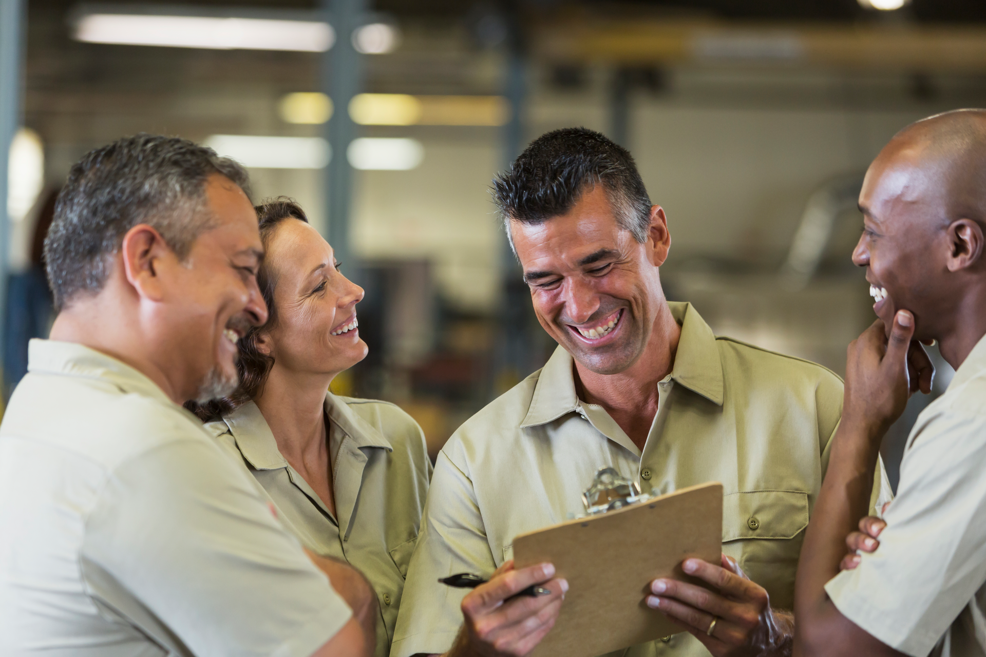 Team of workers laughing in service shop
