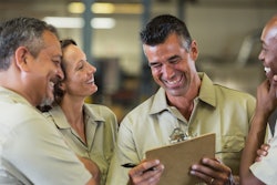Team of workers laughing in service shop