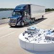 A blue Volvo tractor trailer with a graphic illustrating connectivity to dealerships and more.