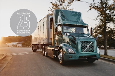 A Volvo truck on the road with a logo that says celebrating 25 certified EV dealerships.