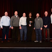 A group of people on stage with an award.