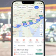 A screenshot of the Trucker Path app with a fuel station in the background.