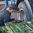Technician working on wheel end and tire