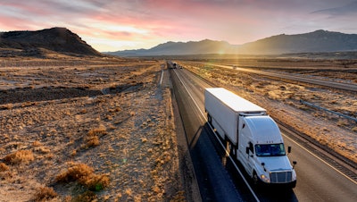 Semi truck driving on highway in desert area