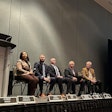 A group of people on a stage talking through a problem.
