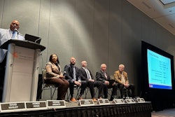 A group of people on a stage talking through a problem.