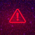 red triangle outline with an exclamation point in the center on top of binary code