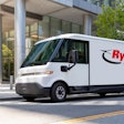 A white Ryder electric van in front of a building.