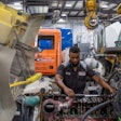 Technicians working on an engine in a truck shop
