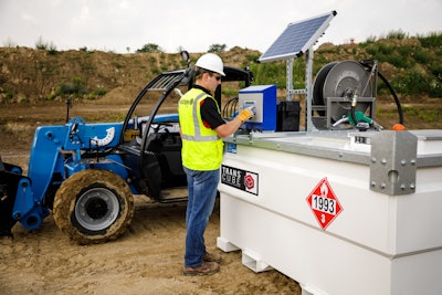 A man presses buttons on an on-site fuel storage tank.