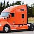 Orange Kenworth truck in parking lot
