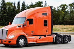 Orange Kenworth truck in parking lot