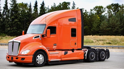 Orange Kenworth truck in parking lot
