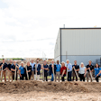A group of people holding shovels on a construction site.