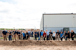 A group of people holding shovels on a construction site.