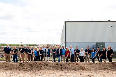 A group of people holding shovels on a construction site.