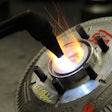 Heating up a fan clutch for remanufacture with a blow torch.