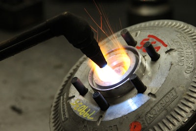 Heating up a fan clutch for remanufacture with a blow torch.