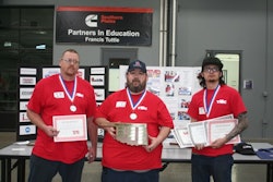 Three people holding certificates and plaques.