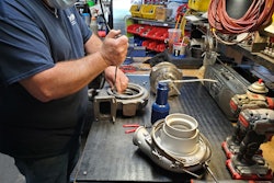 Someone works on remanufacturing a turbocharger.