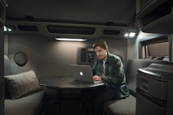 A man works at a retractable desk in a Volvo truck.