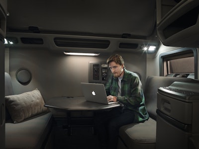 A man works at a retractable desk in a Volvo truck.