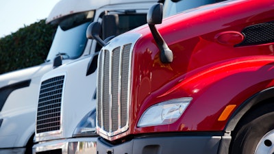 White and red trucks in a lot