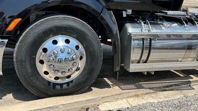 A truck's steer tire is propped against a curb at the Uvalde Proving Grounds.