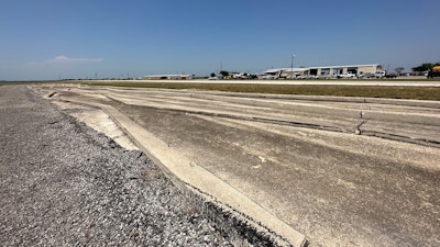 Different-sized curbs in rows with a larger oval track and garage in the background.