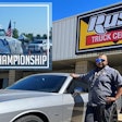 A man standing next to a silver Dodge Challenger in front of Rush Truck Centers, with an inset photo of a white Class 8 truck flying American flags.