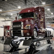 A red Mack Class 8 truck on a vehicle lift in the newly remodeled Mack Experience Center in Allentown, Pennsylvania.