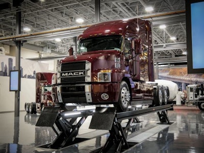 A red Mack Class 8 truck on a vehicle lift in the newly remodeled Mack Experience Center in Allentown, Pennsylvania.