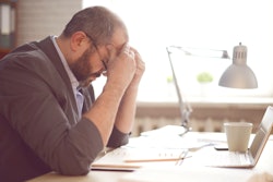 Mature man at computer frustrated.