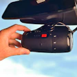 A hand adjusting a dash camera.