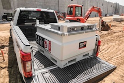 A fuel tank in the back of a pickup truck on a construction site.
