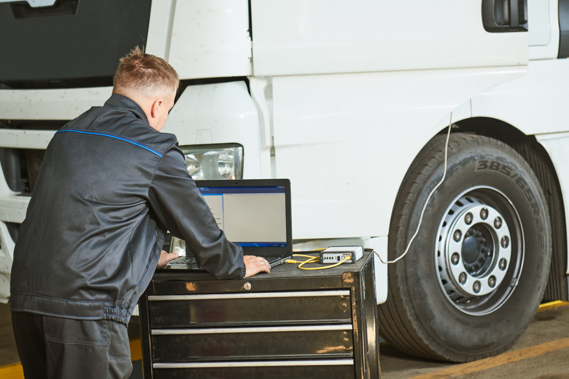 technician using a laptop on a semi repair