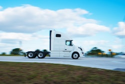 White tractor isolated against sky on highway
