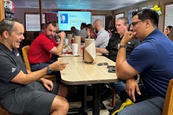 A group of people sit at a table in a restaurant.
