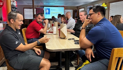 A group of people sit at a table in a restaurant.