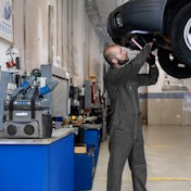 A man working in a shop with a portable cooler.