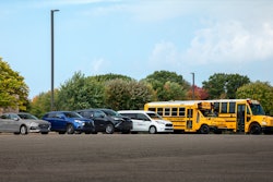 A fleet of First Student vehicles in a parking lot.