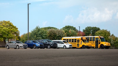 A fleet of First Student vehicles in a parking lot.