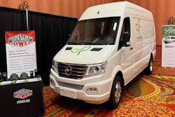 A van in a conference room display area with signs for IP Truck.
