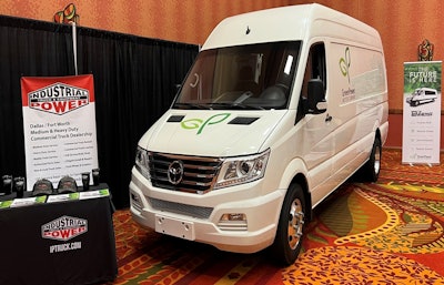 A van in a conference room display area with signs for IP Truck.