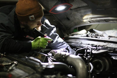 A tech works under a hood at JE-CO.