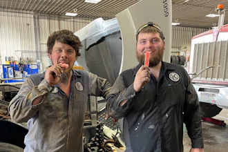 Two men eating popsicles in a garage