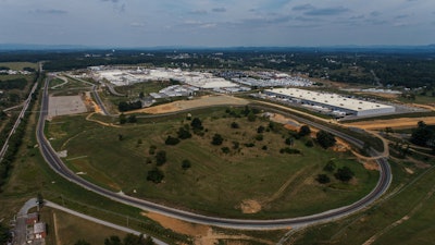 An aerial view of an off-road track with a large plant in the background.