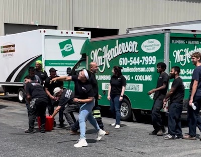 People toss water balloons in a parking lot on a sunny day.